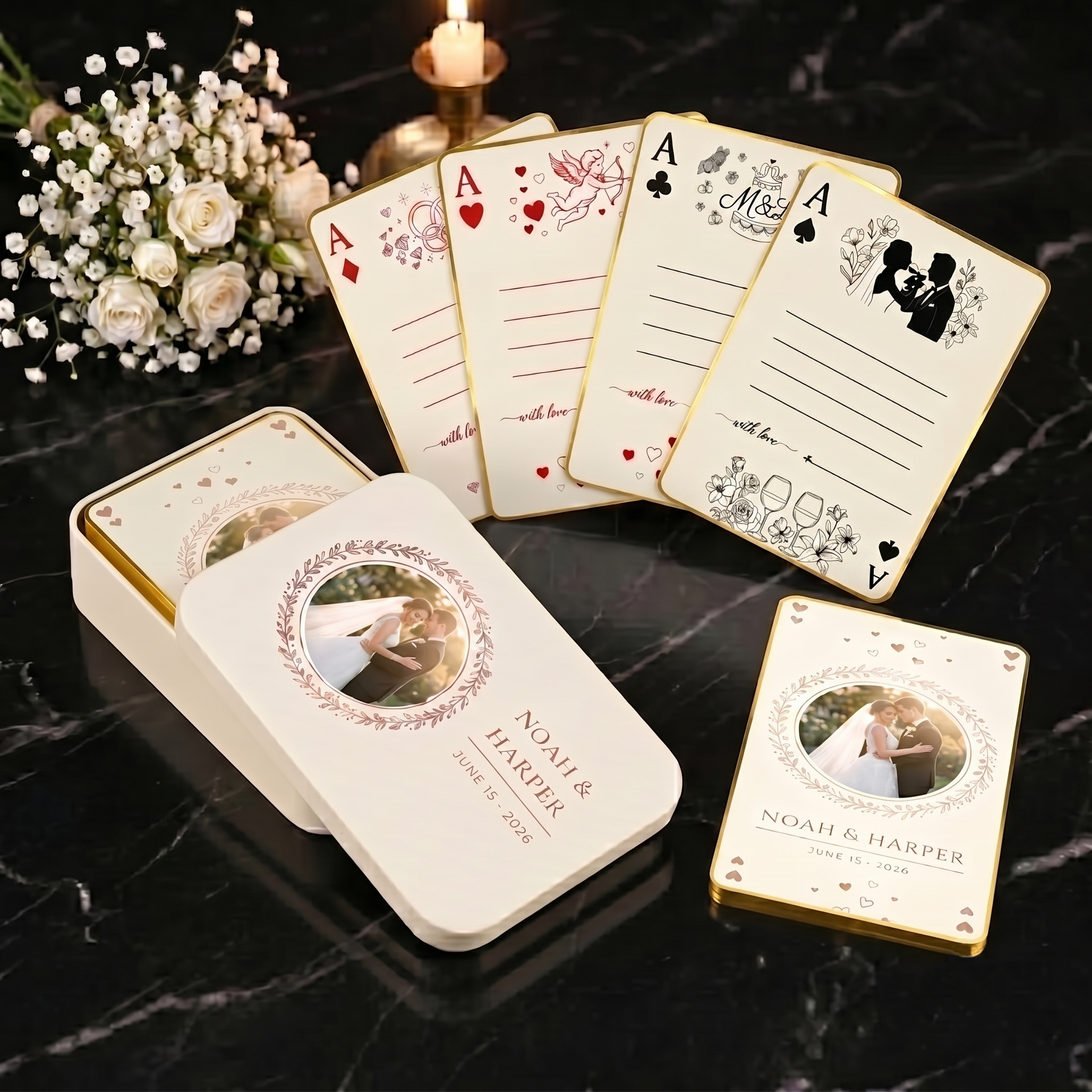Custom wedding playing cards with a printed tin box, gold-edged cards and four signature designs on black marble with white roses and candlelight